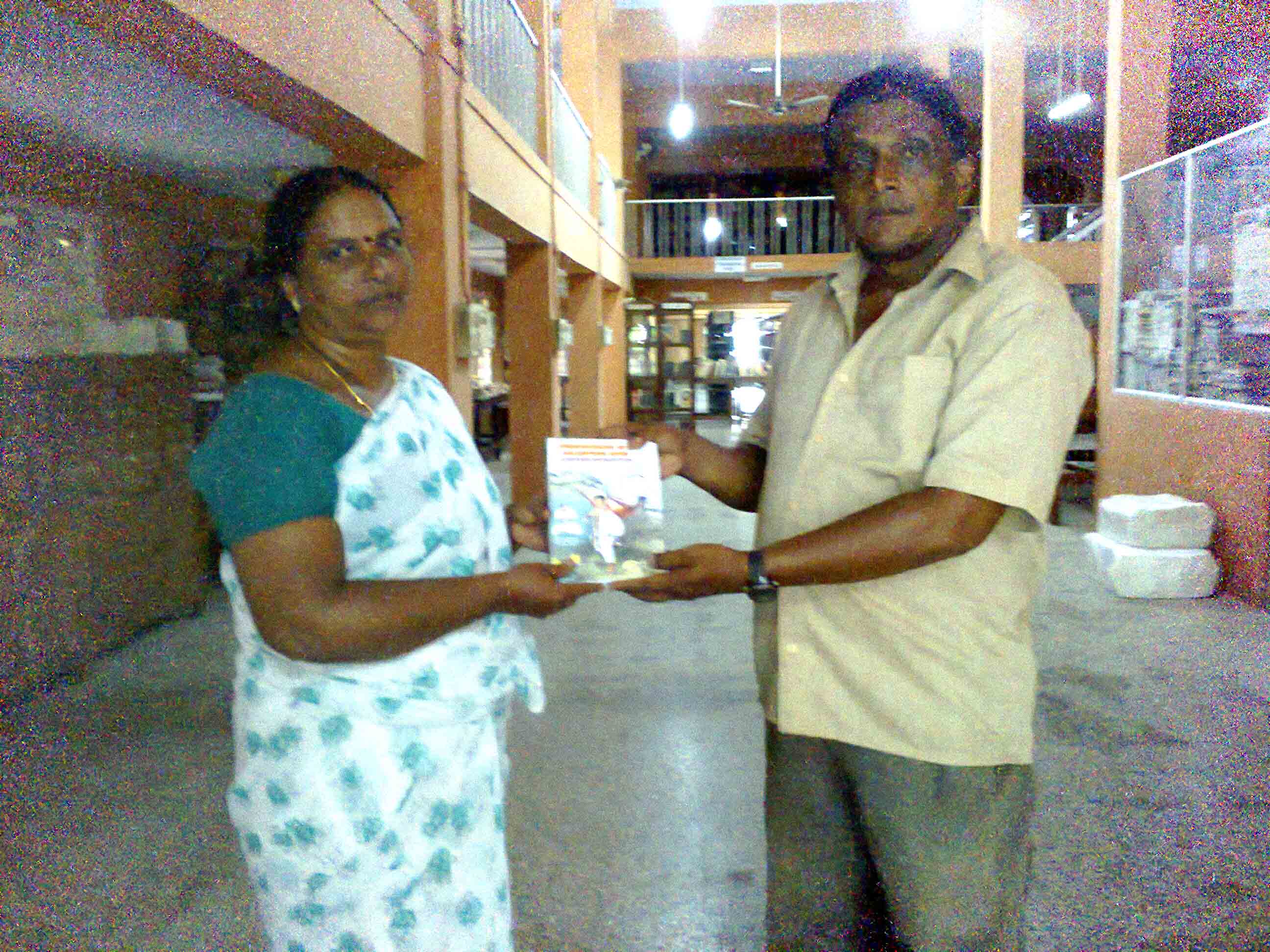 Mathew gurukkal giving copy to Librarian Susamma, katcheri jn,kollam