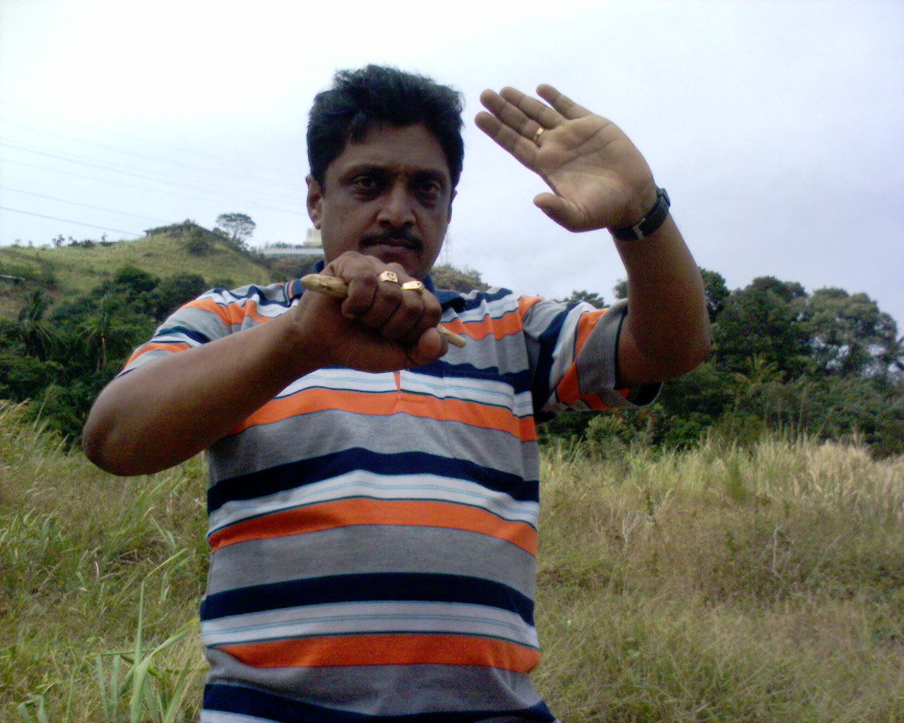Performing Marma-vadi attack, in background is Buddha temple at Balangoda